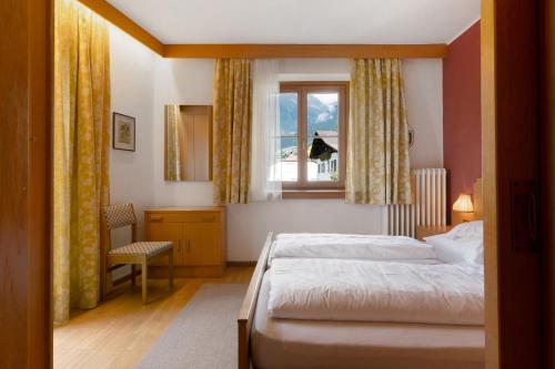 a bedroom with two beds and a window at Unterdornerhof Algund in Lagundo