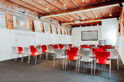 a conference room with red chairs and a screen at Relais de L'Empereur in Genappe