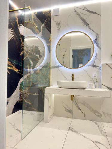 een badkamer met een wastafel en een spiegel bij Apartament Portowy in Giżycko