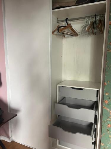 a white refrigerator with empty shelves in it at Chambre et salle de bains autonome dans un logement élégant in Courbevoie