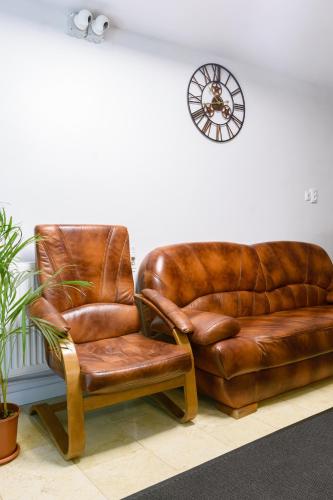 two leather chairs and a couch in a room at Hotel Palas Grand View in Iaşi