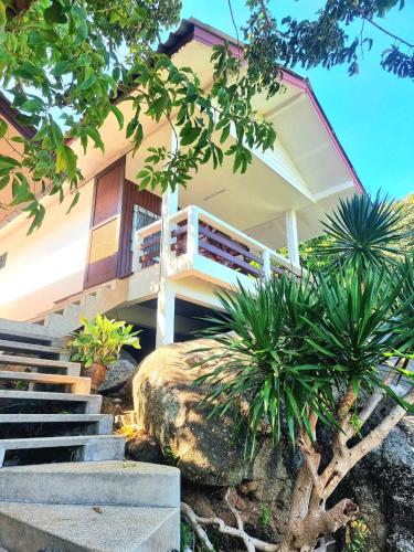 a house with stairs and plants in front of it at Floral House in Lamai