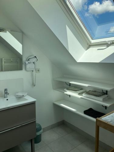 La salle de bains est pourvue d'un lavabo et d'une lucarne. dans l'établissement Maisonette proche mer, à Saint-André-des-Eaux