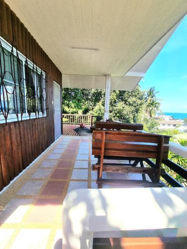 two benches on a porch with a view of the ocean at Floral House in Lamai