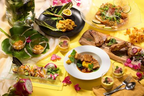 a table with plates of food on a yellow table at ANA Crowne Plaza Kanazawa by IHG in Kanazawa