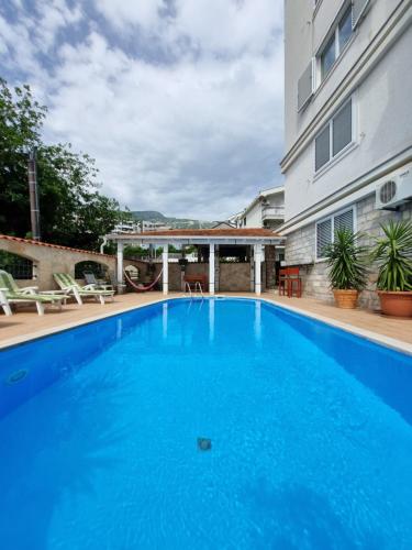a large blue swimming pool next to a building at Sunny Hill Residence in Becici