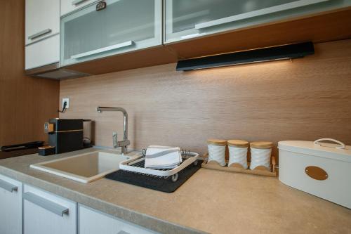 a kitchen with a sink and a counter with towels at JEZERSKA RESIDENCE Palić in Palić