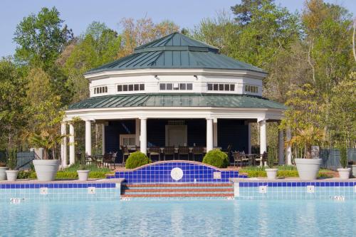 a gazebo and a swimming pool in front of a house at Hilton Vacation Club Greensprings Williamsburg in Williamsburg