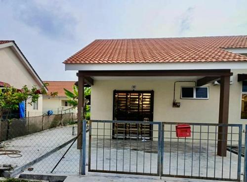 a house with a fence in front of it at Homestay harmonis kuantan in Kuantan