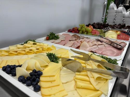 a buffet of different types of cheese and fruit at Apartamenty Rondo in Świnoujście