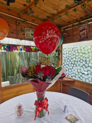a red balloon sitting on top of a table with flowers at Cabaña Los Linos in Guasca