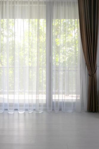 an empty room with a window with white curtains at Hotel Palas Grand View in Iaşi