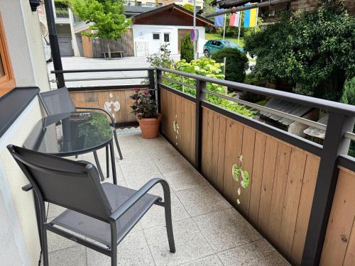 a balcony with two chairs and a table at MittenDrin in Wildschönau