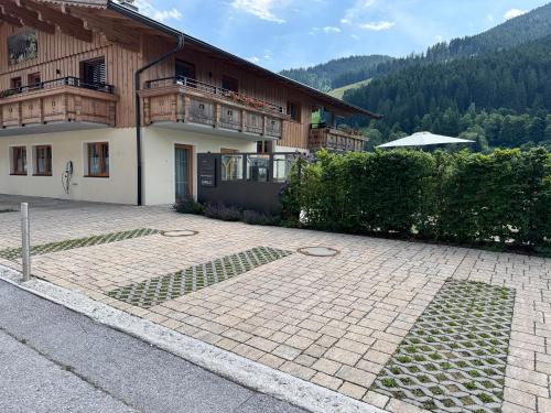a house with a brick driveway in front of a building at MittenDrin in Wildschönau
