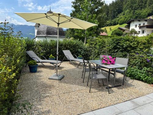 a patio with a table and chairs and an umbrella at MittenDrin in Wildschönau