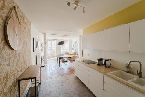 une cuisine avec des placards blancs et une salle à manger dans l'établissement Le stratégique - Hyper Centre Verdun, à Verdun-sur-Meuse