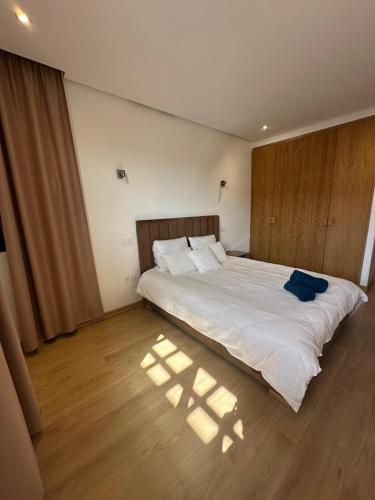 a bedroom with a large bed with white sheets at Villa familiale a 10km du boulevard Mohamed VI in Marrakesh