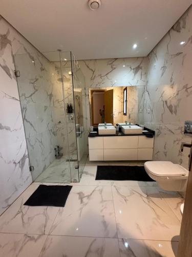 a bathroom with a toilet and a glass shower at Villa familiale a 10km du boulevard Mohamed VI in Marrakesh