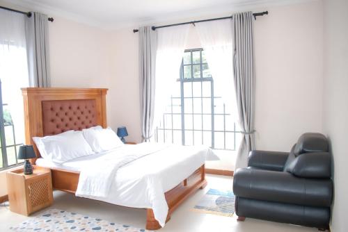 a bedroom with a bed and a chair and a window at Luxury Peace House in Arusha