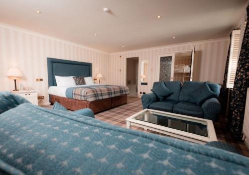 a bedroom with a bed and a living room with a couch at Lakeside Hotel and Spa in Newby Bridge