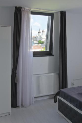a bedroom with a window with a view of a city at Hotel Palas Grand View in Iaşi