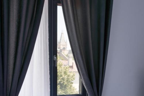 a window with black and white curtains with a view at Hotel Palas Grand View in Iaşi