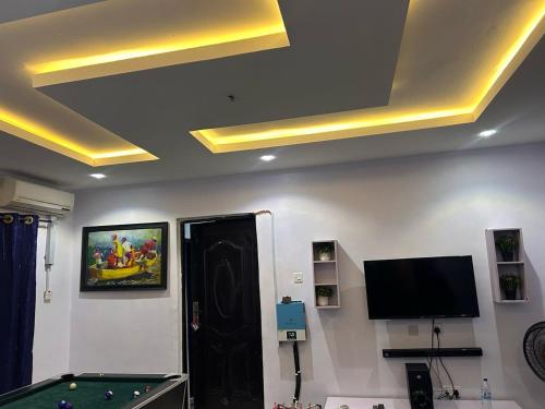 a room with a pool table and a tv on the ceiling at Prime Apartment in Alimosho