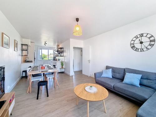 un salon avec un canapé bleu et une table dans l'établissement L'Urbaine, Maison de ville spacieuse, Jardin, WIFI, à La Roche-sur-Yon