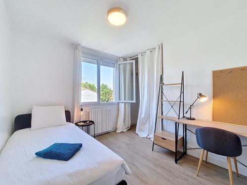 une chambre avec un lit, un bureau et une fenêtre dans l'établissement L'Urbaine, Maison de ville spacieuse, Jardin, WIFI, à La Roche-sur-Yon