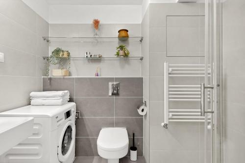 a bathroom with a washing machine and a toilet at Slnecnice studio with parking and 24 hour check in in Bratislava