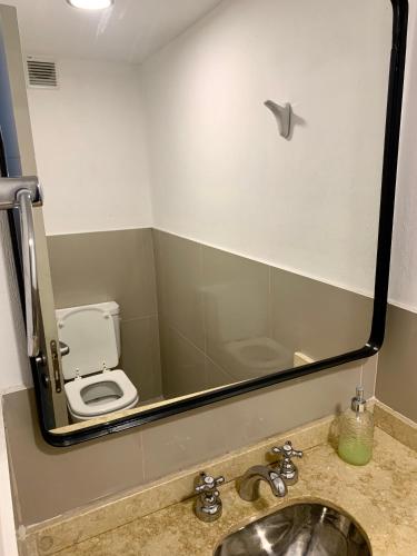a bathroom with a sink and a toilet in a mirror at Güemes Premium, 2 dorm con Vista a las Sierras ALOHA #2 in Cordoba