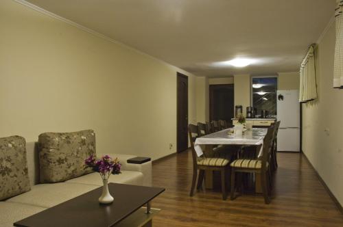 - une salle à manger et un salon avec une table et des chaises dans l'établissement Guest house Altay, à Karakol