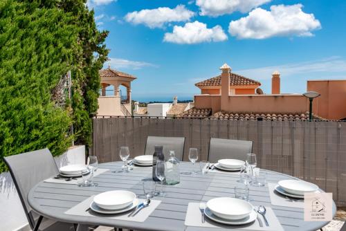 ポロップにあるCasa Ponoig - Piscine, pétanque et vue mer by lg home conciergerieのテーブル(皿付)、パティオ(ワイングラス付)