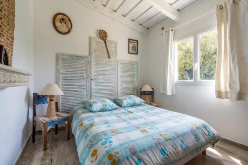 Un dormitorio con una cama y un reloj en la pared. en La bergerie 1, en Bonifacio