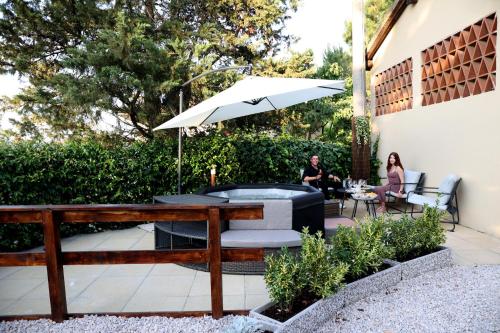two people sitting at a table with an umbrella at Tognazzi Casa Vacanze - Appartamento Due Archi in San Gimignano