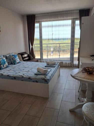 a bedroom with a bed and a large window at Apart Hotel Iglika in Pomorie