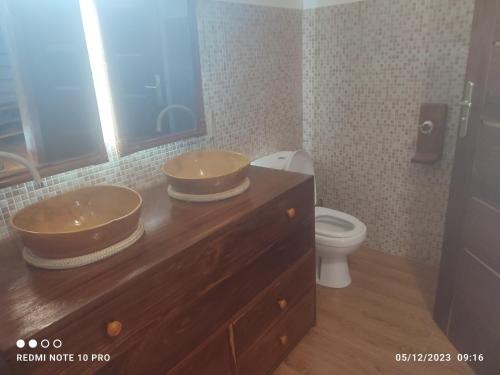 a bathroom with two sinks and a toilet at Studio au bord de la lagune in Assinie