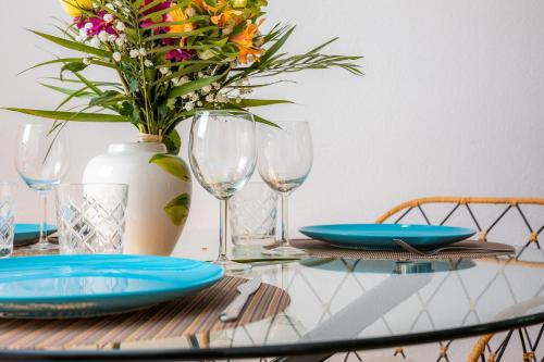 a table with plates and glasses and a vase with flowers at Apartamento Can Jaume in Artá