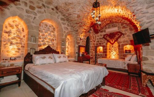 Un dormitorio con una cama y una pared de piedra. en Ali paşa konağı mardin, en Mardin