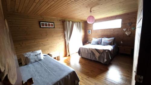 a bedroom with two beds and a window in a room at Villa Maori Tea Rapa Nui, Easter Island with ocean view in Hanga Roa