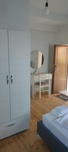 a bedroom with a bed and a white cabinet and a desk at Ionian Sunset House in Piqeras