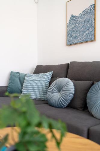 a living room with a couch with blue pillows at The Skippers Nest in San Miguel de Abona