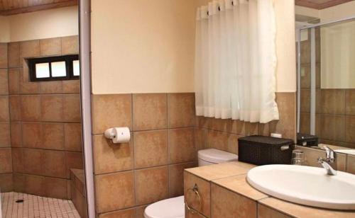 un bagno con lavandino, WC e specchio di Fairways at Drakensberg Gardens Resort Timeshare a Underberg