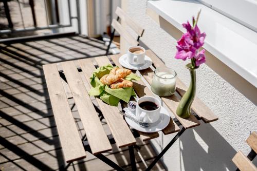 a table with a plate of food and a vase of flowers at Hotel Donau-Ries in Mertingen