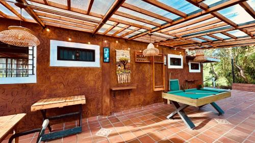 Un patio con mesa de billar y techo de madera. en Finca campestre mi retoño, en Medellín