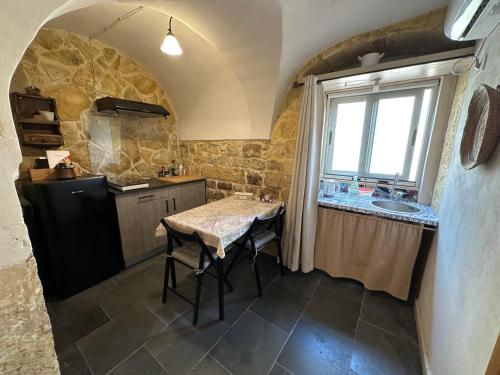 a kitchen with a table and a sink and a window at Cuturissi Hospitality & Wellness in Ragusa