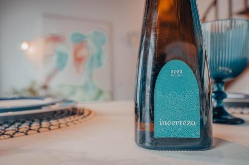 eine Flasche auf einem Tisch neben einem Laptop in der Unterkunft Yellow House - Casa 2 in Angra do Heroísmo