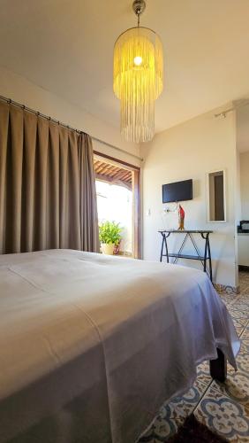 a bedroom with a large bed and a chandelier at Morro Branco Pousada e aptos in Natal