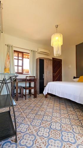 a bedroom with a bed and a table in it at Morro Branco Pousada e aptos in Natal