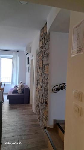 a room with a bed and a stone wall at Istrabella Apartment in Koper